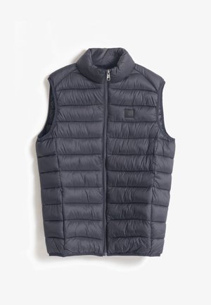 Chaleco acolchado sin mangas en color azul marino, con un alto cuello, cremallera frontal y patrón de costura horizontal. Textura suave, diseño ligero.