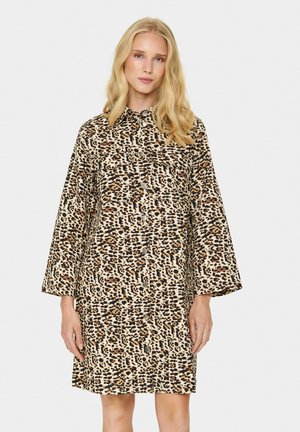 Leopardprint jurk met kraag, lange mouwen en knoopsluiting. Heeft een beige achtergrond met bruine en zwarte vlekken. Lichtgewicht stof.