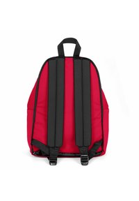 Mochila roja con correas acolchadas negras y un asa en la parte superior. Fabricada con un material duradero, presenta un diseño simple y curvado sin bolsillos exteriores.