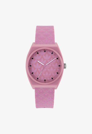 Montre analogique rose avec bracelet et cadran à motifs présentant des logos tréflés répétés, index heures noirs et aiguilles argentées indiquant 10:09:34.