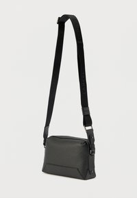 Fekete, texturált bőr keresztpántos táska állítható, "LANCEL" felirattal dombornyomott szövetpánttal és ezüstszínű fém hardverelemekkel.