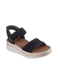 Sandales compensées en tissu noir avec deux larges sangles et une semelle intérieure rembourrée marron. Présente une semelle intermédiaire en jute et une semelle extérieure en caoutchouc texturé.