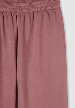 Miękkie, lekkie, różowe dresy z elastycznym pasem i szczegółami kieszeni bocznych; materiał ma gładką teksturę.