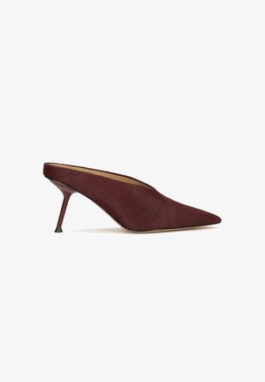 Burgundi velúr mules, hegyes orral és 10 cm magas stiletto sarkú. Kiemelkedő jellemzője a kivágott dizájn és a sima bélés.