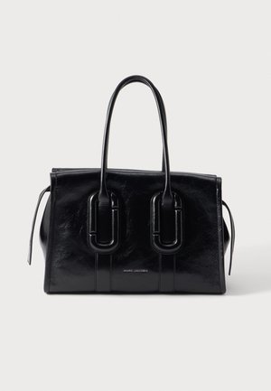 Sac à main en cuir noir Marc Jacobs avec doubles poignées et une forme rectangulaire structurée sur un fond clair.