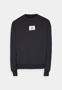 Sudadera negra con cuello redondo, mangas largas y un parche de logo blanco en el frente que presenta una silueta y una firma. Material suave de algodón.