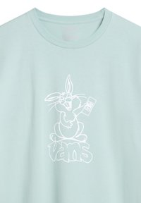 Camiseta azul clara hecha de algodón suave con un gráfico de un conejo de dibujos animados en blanco y el texto "Vans" debajo. Cuello redondo, mangas cortas.