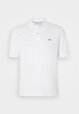 Polo-shirt blanc en coton, doté d'un col classique, de manches courtes et d'un petit logo brodé sur la poitrine gauche.