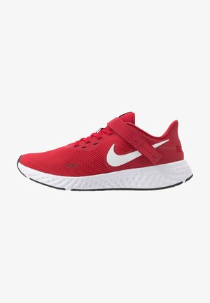 Baskets de sport rouges avec semelle blanche, virgule Nike blanche, lacets et bride réglable sur le dessus pour un maintien sécurisé.