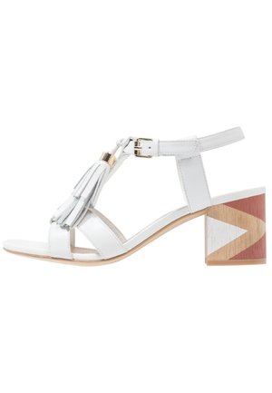 Hvidt læder sandal med åben tå og ankelsnor, guldspænde, kvastdetalje og blokhæl med geometrisk træmønster i brun, beige og hvid.