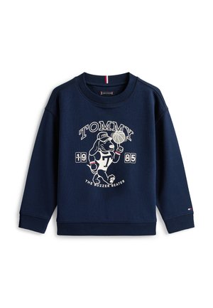 Marineblauer Pullover mit einem Cartoon-Hund, der einen Basketball dreht, sowie den Texten "TOMMY 1985" und "THE BUZZER BEATER" auf der Vorderseite.