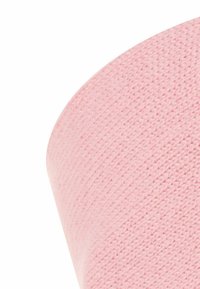 Roze gebreide stof met een gestructureerd oppervlak, met een soepele curve en een diagonaal patroon. Het materiaal lijkt zacht en flexibel.