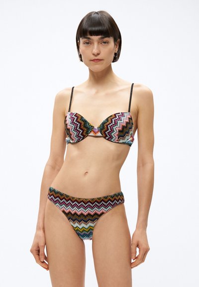 Mönstrad tvådelad bikini med zickzackmönster i flera färger, mjukt tyg, bygelstöd och tunna svarta band.