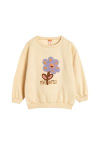 Sudadera amarilla con puños acanalados, presenta un diseño de flor púrpura y el texto "MINI ARTISTA" en marrón en la parte inferior. Tejido suave y cuello redondo.