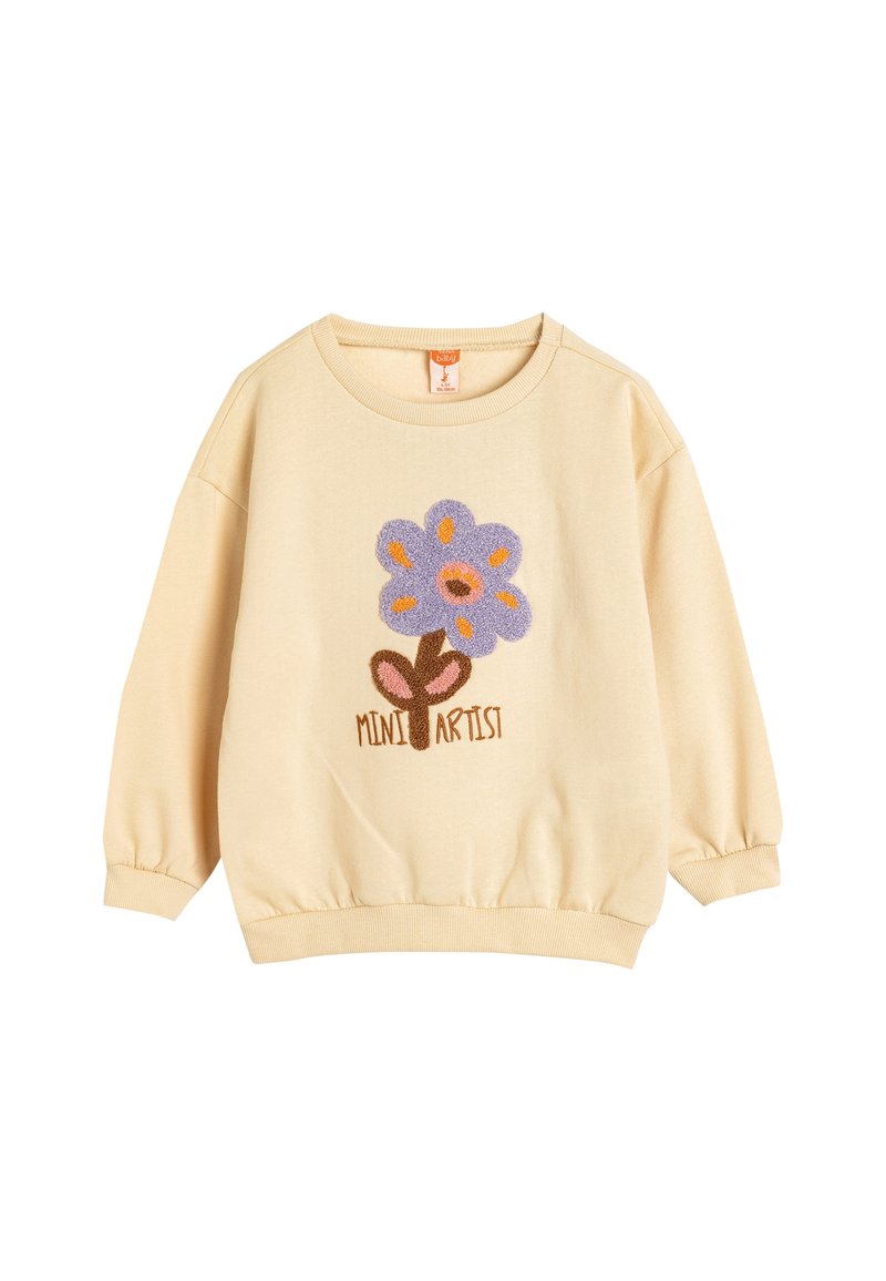 Sudadera amarilla con puños acanalados, presenta un diseño de flor púrpura y el texto "MINI ARTISTA" en marrón en la parte inferior. Tejido suave y cuello redondo.