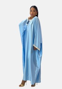 Lyseblå kaftan i silkeagtigt stof med brede ærmer og snoretræk i halsen. Udsmykket med dekorativt bånd langs ærmerne.