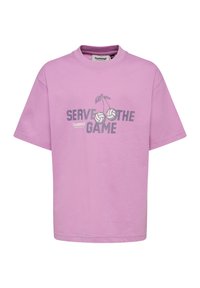 T-shirt lilas à manches courtes avec col rond, présentant le texte « Serve the Game » et deux ballons de volley dessinés comme des cerises à l'avant.