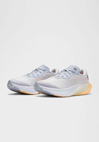 Scarpe sportive grigio chiaro con tomaia in mesh, soletta morbida e suola in gomma testurizzata. Presentano un design con lacci e una suola arancione a contrasto.