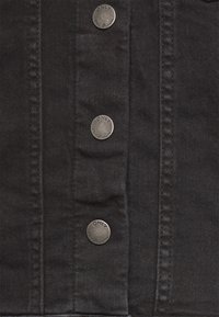 Svart denimjacka med detaljer som fem silverfärgade metallknappar med "ONLY" ingraverat, sydda sömmar och en slät tygtextur.