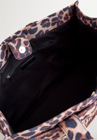 Geantă de mână din pânză, cu exterior imprimat cu leopard roz și negru, interior solid negru, închidere cu capse și buzunar cu fermoar.