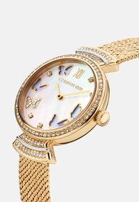 Reloj tono oro con una esfera redonda de nácar, motivos de mariposa, detalles de cristal y correa de malla para un acabado texturizado.