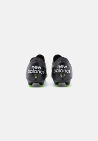 Mustad mustrennijalatsid tekstureeritud pinnaga, roheliste detailide ja valge "new balance" brändimisega. Sujuv, voolujooneline kuju ja tapid.