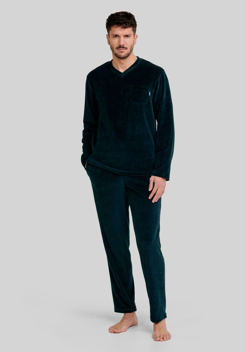 Conjunto de pijama de terciopelo verde oscuro para hombre que incluye una camiseta de manga larga con escote en V y un bolsillo, y pantalones ajustados a juego. Textura suave, ajuste relajado.