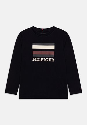 Camiseta negra de manga larga con dos franjas horizontales beige y marrón y texto "HILFIGER" debajo, centrado en el pecho.