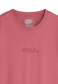 Camiseta de algodón rosa con cuello redondo y logo "vans." bordado en color a juego en el pecho. Textura suave, diseño casual.