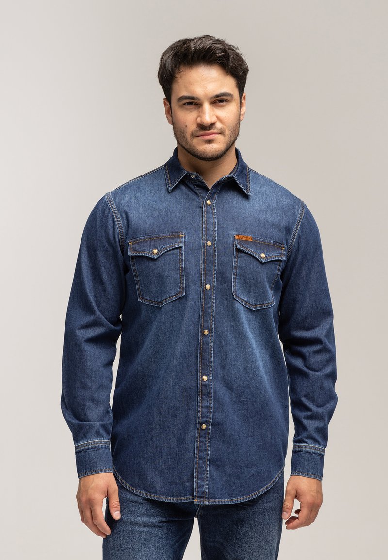 Granatowa koszula z denimu, z długimi rękawami, z przodem na guziki, dwoma kieszeniami na piersi oraz kontrastowym przeszyciem. Standardowy kołnierzyk i swobodny krój.