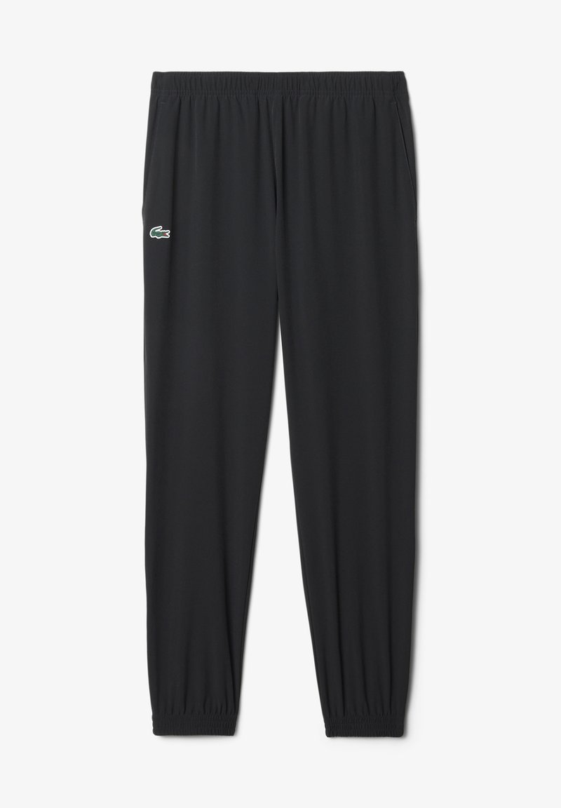 Schwarze Sporthose mit elastischem Bund und Bündchen, mit einem kleinen grünen Krokodil-Logo auf dem linken Oberschenkel.