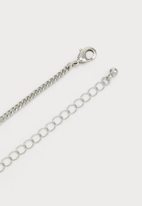 Sølv kædekrave med en lobster clasp i den ene ende og en justerbar løbende kæde med en rund perle i den anden ende.