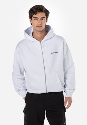 Vit zip-up hoodie med en framficka och logotext. Har en huva med dragsko och ribbade ärmslut. Tillverkad av mjukt bomullsmaterial.