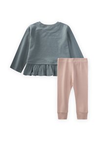 Dvojdielny outfit s tyrkysovým dlhým rukávom so volánovým lemom a svetloružovými rebrovanými legínami s priliehavými manžetami.