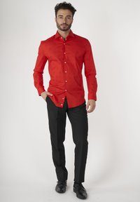 Rode lange mouwen shirt met subtiel patroon, button-down kraag en witte knopen, gecombineerd met zwarte broek en zwarte schoenen.