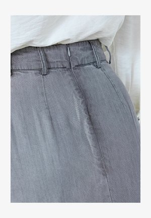 Siva prugasta tkanina glatke teksture, plisirani dizajn i zatvarač u struku. Pogodno za ležerno nošenje.