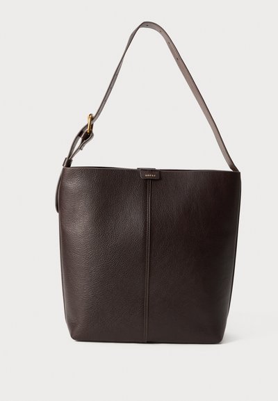 Sac à épaule en cuir marron foncé avec une bandoulière réglable, une boucle en or et un petit logo central sur un fond uni.