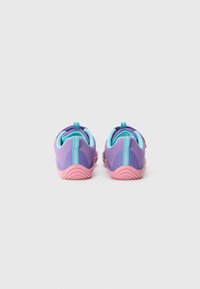 Des chaussures violettes et roses avec une tige en tissu texturé, dotées d'accents turquoises et d'une semelle rose striée, conçues pour le confort et la flexibilité.