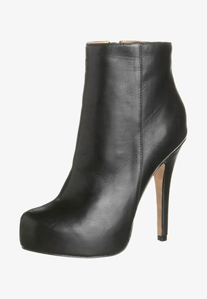 Stivale alla caviglia in pelle nera con tacco a stiletto, punta arrotondata e suola piattaforma. Texture liscia con dettagli di cuciture minime.