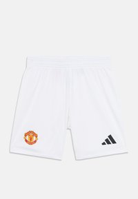 Pantaloni corti da calcio bianchi realizzati in tessuto leggero, con logo del Manchester United in rosso e giallo, e un accento nero Adidas sul lato.