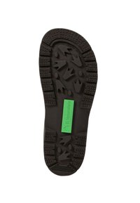 Suela de zapato de goma negra con patrones de agarre texturizados, con una etiqueta verde que dice "El Naturalista" cerca del centro.