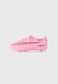 Crampons de football Nike Mercurial roses avec un swoosh orange, des crampons blancs et des lacets sur un fond blanc uni.