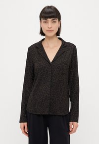 Camisa de mangas longas com padrão de leopardo, em tons de preto e castanho, corte descontraído, um bolso, fechamento frontal com botões, textura de tecido suave.