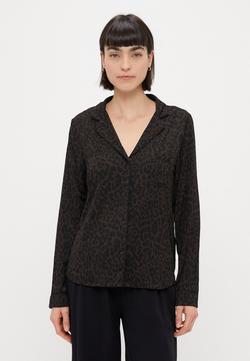 Camisa de mangas longas com padrão de leopardo, em tons de preto e castanho, corte descontraído, um bolso, fechamento frontal com botões, textura de tecido suave.