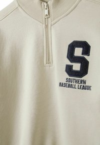 Felpa beige con zip a metà, con colletto a costine, caratterizzata da una lettera "S" ricamata e testo "SOUTHERN BASEBALL LEAGUE" in blu navy. Texture morbida.