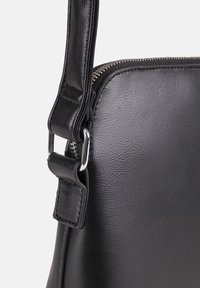 Borsa in pelle nera con una texture liscia, chiusura con zip e una cintura robusta con accenti in metallo argentato.