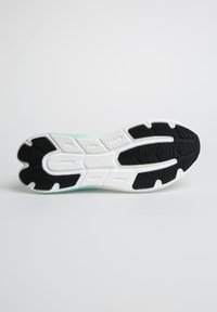 Black and white running shoe outsole with textured grip patterns; central groove for flexibility; mint-green highlight along the edge.