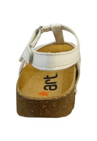 Hvide lædersandaler med korksål, justerbar rem og en struktureret fodseng. Logoet er trykt i sort og orange på indersålen.