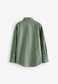 Zöld pamut ing gallérral, hosszú ujjakkal és gombos mandzsettával. Sima textúra, minimalista design egyetlen gombbal a nyaknál.
