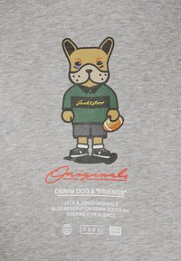 Camiseta de algodón gris con un bulldog francés de dibujos animados que lleva una camiseta y pantalones cortos verdes, sosteniendo un balón de fútbol naranja, con un diseño de texto en negrita.